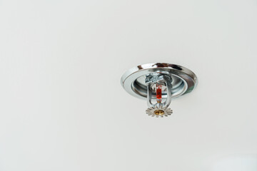 Fire Sprinkler detector mounted on roof in home or apartment. Safety and conflagration security concept - obrazy, fototapety, plakaty