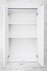 Empty shelves for product display, clean white cabinet, light grey wall background. Empty white open cabinet with shelves in bathroom. copy space