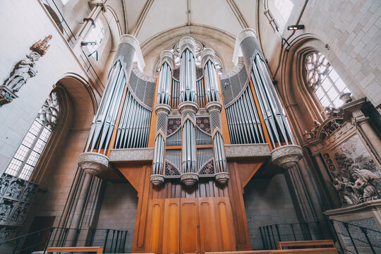 25 July 2022, Munster, Germany: Huge Organ with shiny pipe rows in interior of a famous Saint Paulus Dom Cathedral interior view.