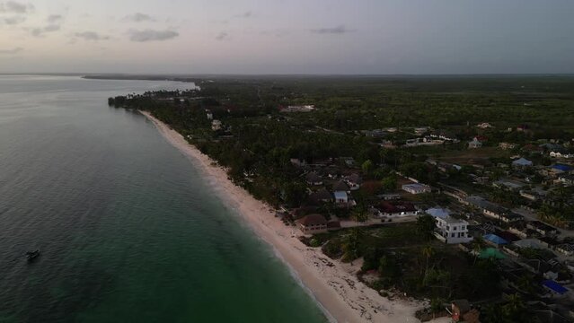 Uroa beach resorts and homes in Zanzibar Island Tanzania Africa during sunset, Aerial pan left shot