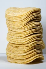 Poster Vertical shot of the stack potatoes chips isolated on gray background © Abinash T/Wirestock Creators