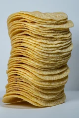 Poster Vertical shot of the stack potatoes chips isolated on gray background © Abinash T/Wirestock Creators