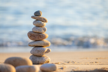 Fototapeta na wymiar Balance pebble stone in the sand beach