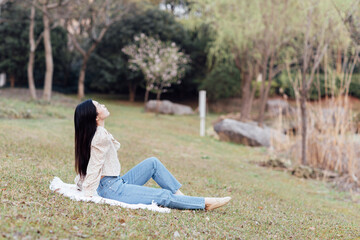 Candid lifestyle Portrait of happy young beautiful asian sexy woman enjoying life outdoor at spring. Smiling millennial girl with perfect clear glow skin and long brunette hair