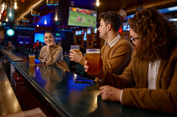 Young male friends flirting with woman at bar counter