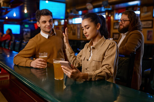 Young woman sitting at bar counter rejecting man - Powered by Adobe