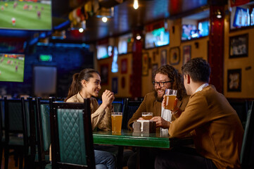 Friends having fun sitting at the table in the pub