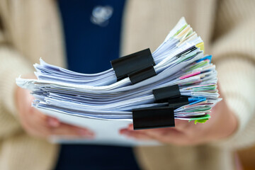 close up the stacking of office female worker and business woman holding a pile of paperwork. 