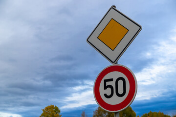 road sign with 50 kmh and right of way, Germany in autumn