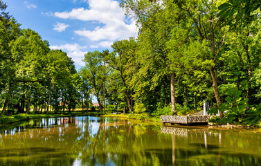 Obraz premium Historic park surrounding XVI century Rozalin Palace with vintage trees and ponds during summer season in Rozalin village in Mazovia region of Poland