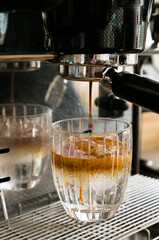 Coffee tonic elaboration with a expresso machine pouring coffee on a cold tonic glass. Barista vertical stills.