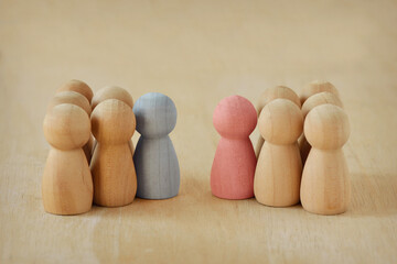 Two groups of wooden pawns with male and female leader facing each other - Concept of competition...