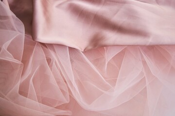 The texture of the fabric is pink tulle and silk. Textile industry for the creation of clothing.