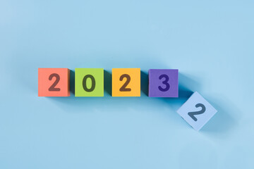 Flipping wooden cubes for new year change 2022 to 2023. New year change and starting concept.