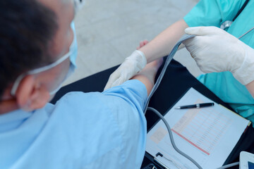 Doctor checking patient's blood pressure in hospital. Cardiology concept