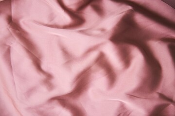 The texture of the fabric is pink silk. Textile industry for the creation of clothing.