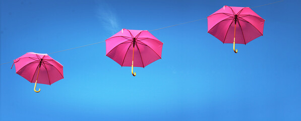 Octobre rose, parapluie rose dans le ciel bleu, concept bannière, avec espace vide pour du texte - obrazy, fototapety, plakaty