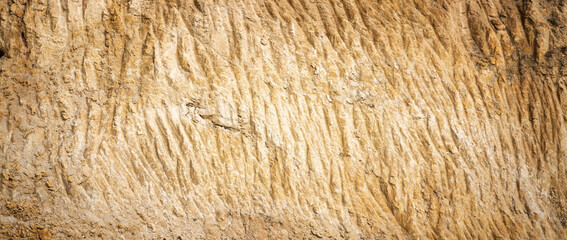 Abstract natural background. Yellow surface sandy quarry slope. Mining of natural materials and construction concept