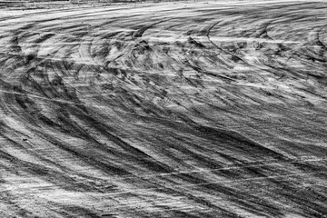 Background with tire marks on road track, Car track asphalt pavement background at the circuit, Abstract asphalt road background with crossing of tires tracks, Black tyre mark on asphalt road.