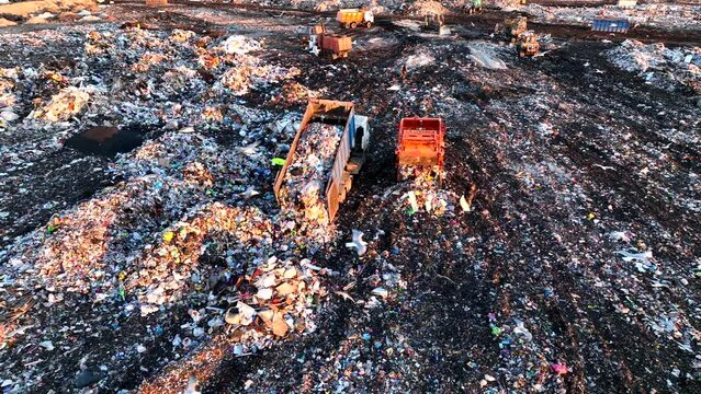 Garbage truck unloads rubbish in landfill. Landfill waste disposal. Garbage dump with waste plastic and polyethylene. Reduce greenhouse gas emissions and methane emissions. Environmental protection.