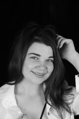 Black and white portrait of an attractive girl on a black studio background