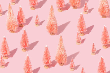 Christmas creative pattern with pink christmas trees on pastel pink background.  New Year celebration creative idea. Retro aesthetic minimal concept .