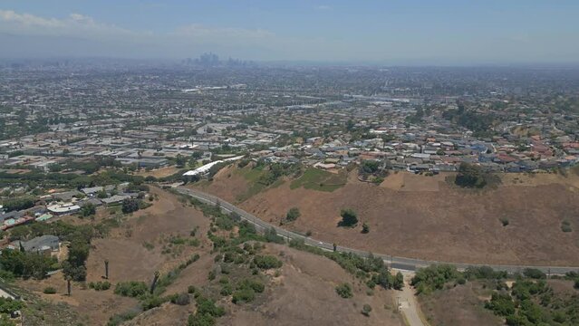 Aerial of Kenneth Hawk State Recreation area with LA cityscape, radio tower, open park and hills