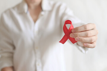 World AIDS and hiv day. Woman in white shirt holds red ribbon. Blood transfusion and donation....