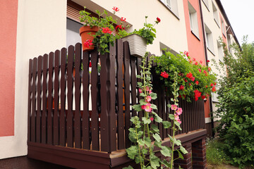 Wooden balcony decorated with beautiful red flowers