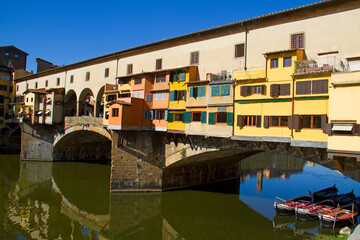 Fototapeta na wymiar Arch bridge, the Ponte Vecchio in Florence, houses reflected in flowing water