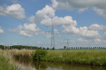 Modern high voltage towers in field on sunny day
