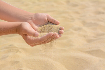 Child pouring sand from hands on beach, closeup with space for text. Fleeting time concept