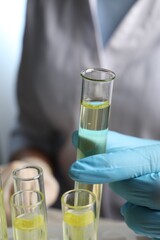 Doctor taking test tube with urine sample for analysis, closeup