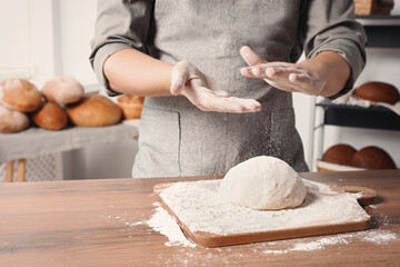 Man preparing dough at table in kitchen, closeup