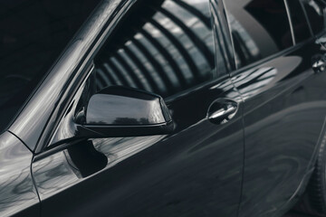 Black luxury business class car, rear view mirror, exterior details.