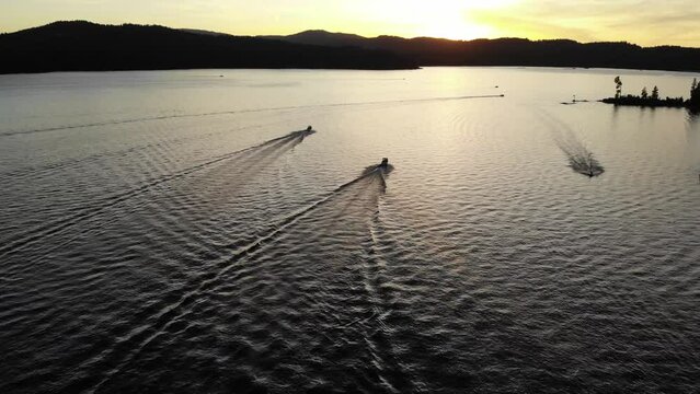 Boats cruising along Lake Couer De'Alene during sunset in the summer