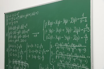 Many different math formulas written on chalkboard