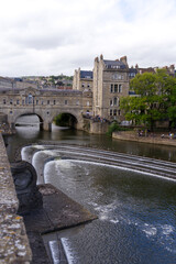 Pulteny Bridge with Avon River at famous City of Bath on a blue cloudy summer day. Photo taken August 2nd, 2022, Bath, United Kingdom.