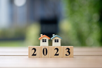 Happy new year 2023. Two house model on 2023 wooden blocks number. New year, New home, Real estate,...