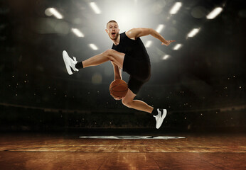 Fototapeta na wymiar Energetic young professional basketball player jumping with ball at basketball court with people fans. Photoreal 3d render of sport arena.