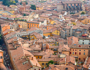 Fototapeta na wymiar Aerial Cityscape view from the tower Asinelli on Bologna old town center with Maggiore square in Italy.Colorful sky over the historical city center with car traffic and old buildings