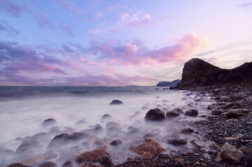 Beautiful landscape with rock sea beach and cloudy sky.