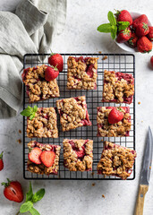 Homemade crumble strawberry bars with oatmeal on the table top view flat lay