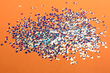 Shiny bright glitter scattered on coral background