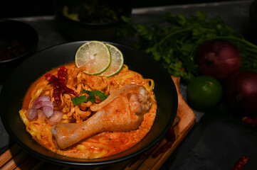 Creamy and slightly spicy yellow curry with chicken drumstick and vegetables. Khao Soi Kai.