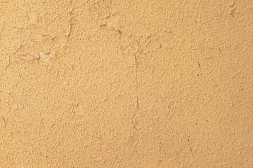 abstract background of an old shabby rough painted ocher wall close up