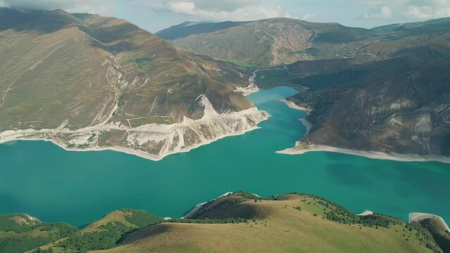 Aerial over lake Kezenoy-am with turquoise water and tall mountains around. Stunning scenery in highlands of Chechen Republic, Russia