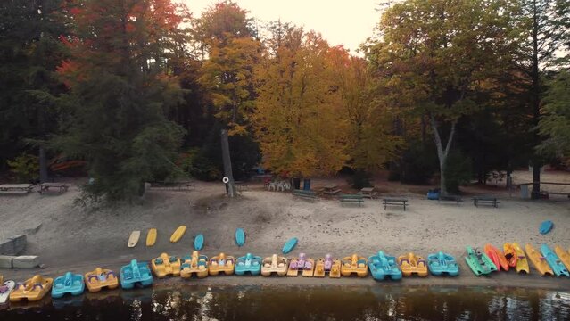 Aerial view of parked pedal boats and canoes in Water Park along the river, recreation in a forest environment