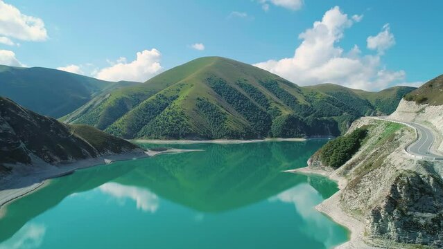 Aerial over lake Kezenoy-am with turquoise water and tall mountains around. Stunning scenery in highlands of Chechen Republic, Russia