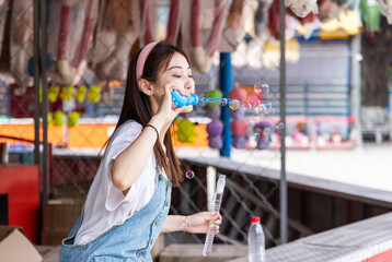 Asian girls blowing bubbles at an amusement park